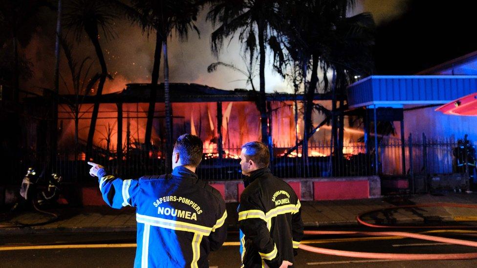 Firefighters try to extinguish a blaze in downtown Noumea on November 5, 2018