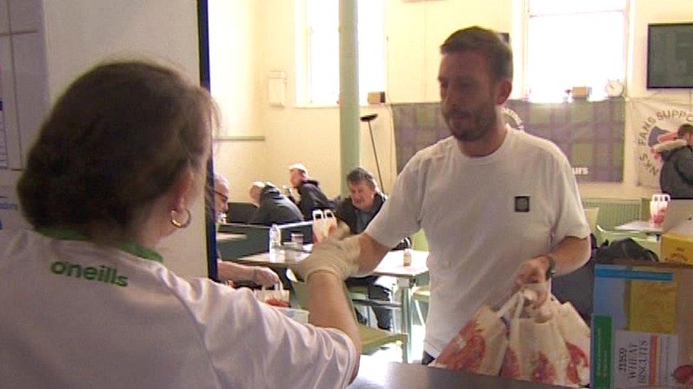 food bank worker giving items to a man