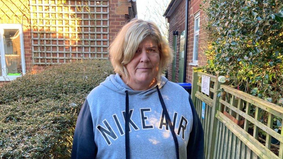 Woman with medium-length blond hair wearing Nike top