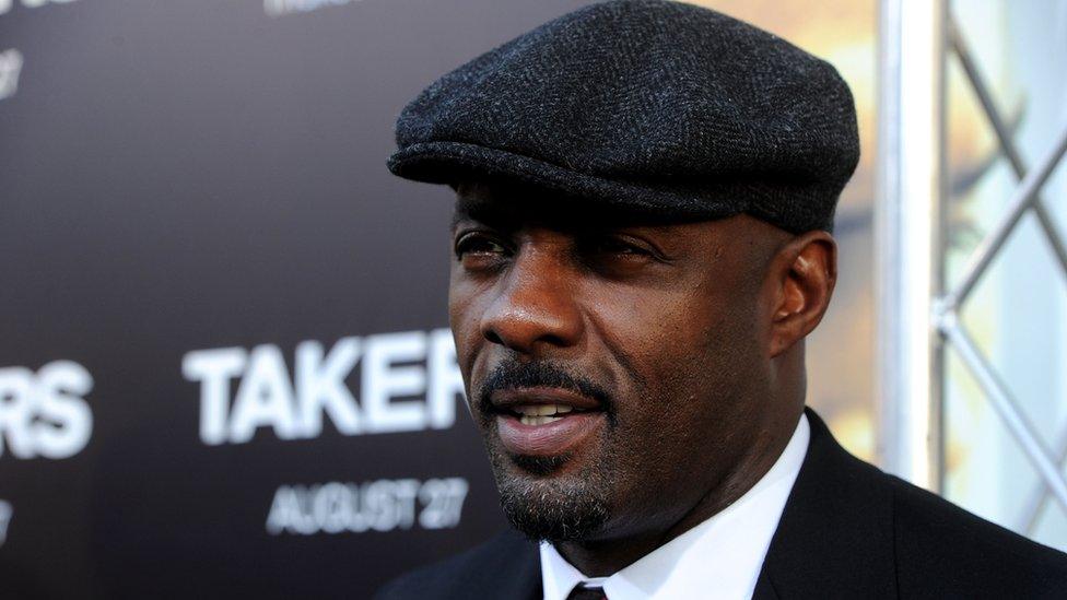 Idris Elba wearing a flat cap