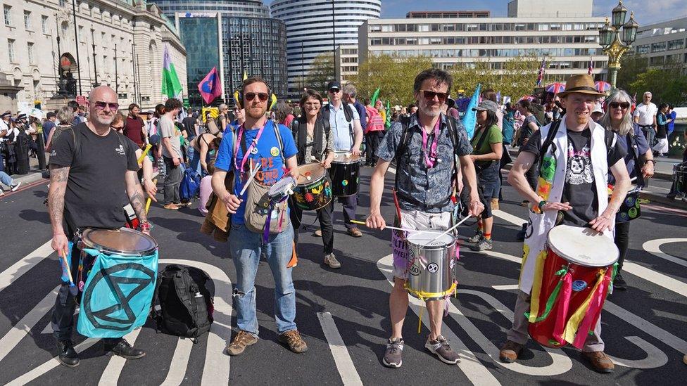 Activists on Westminster Bridge playing bongos