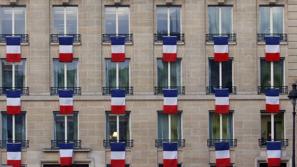 Flags hang from a building near Les Invalides