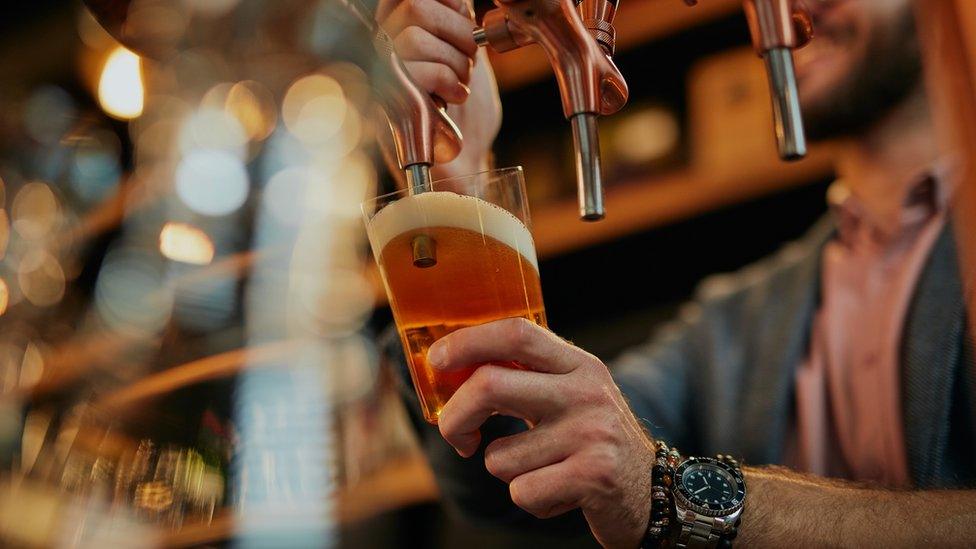 Man pulling pints in pub