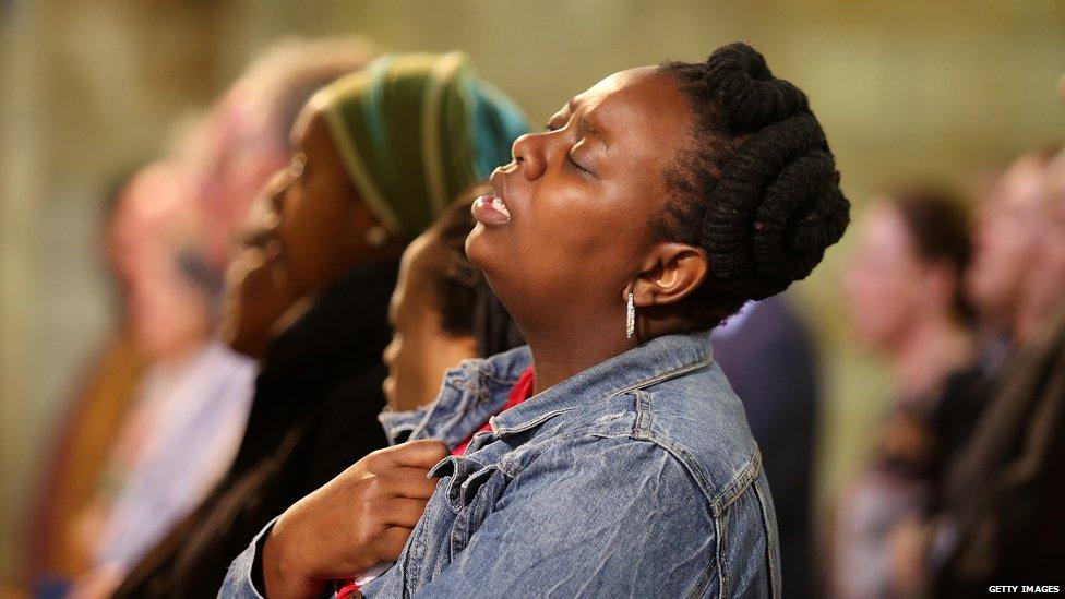 A mourner sings Nkosi Sikelel' iafrica following the death of Nelson Mandela in December 2013