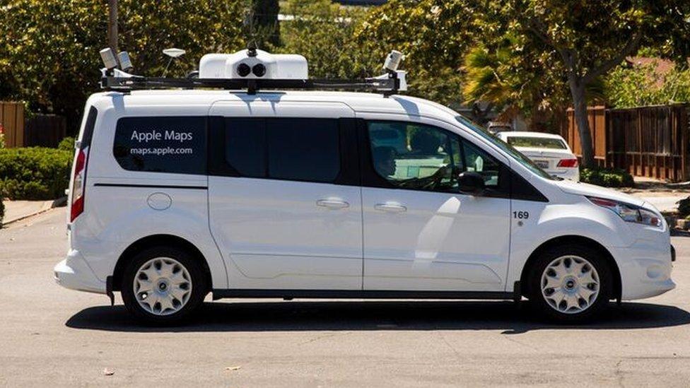 A picture of a white van with camera equipment on the roof and 'Apple Maps' written on it