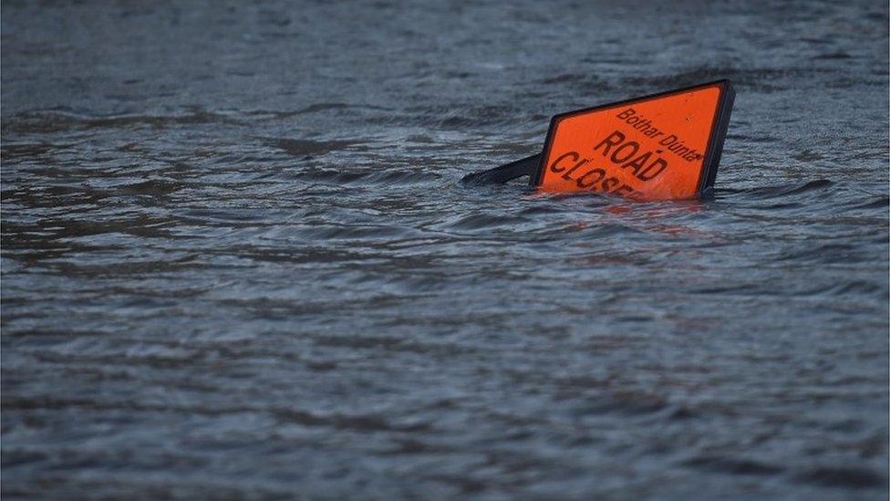 A "road closed" sign is seen submerged in floodwater during Storm Ophelia in Galway, Ireland 16 October 2017