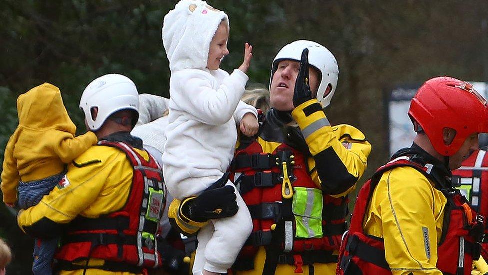 High five: Emergency service workers were praised after hundreds of people were rescued on Sunday