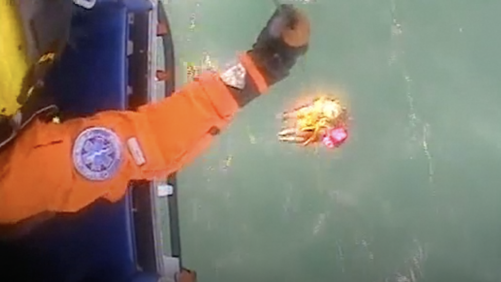 Swimmer being pulled out of the water through a helicopter rescue