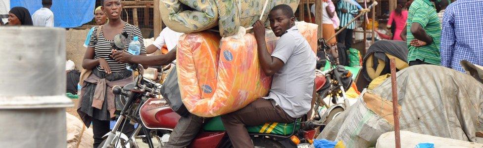 People on a motorbike with mattresses preparing to flee Juba, South Sudan - July 2016