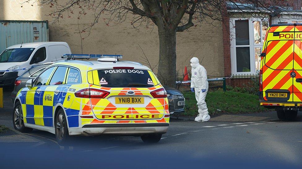 Police vehicles and forensic officers on the street