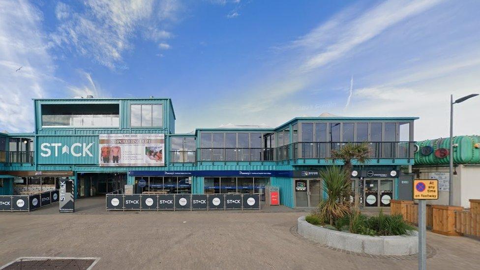 Blue rectangular boxes with windows linked together to form an entertainment venue