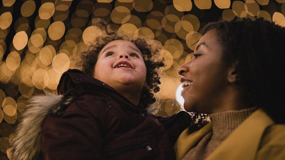 A woman and a child look at Christmas lights