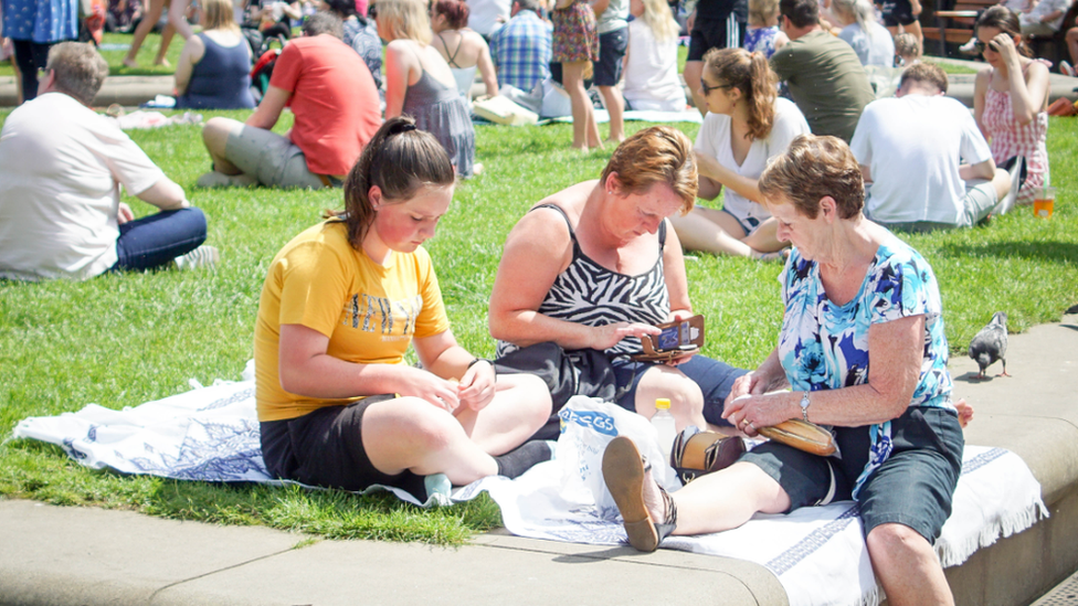 Three women have a picnic in the sun