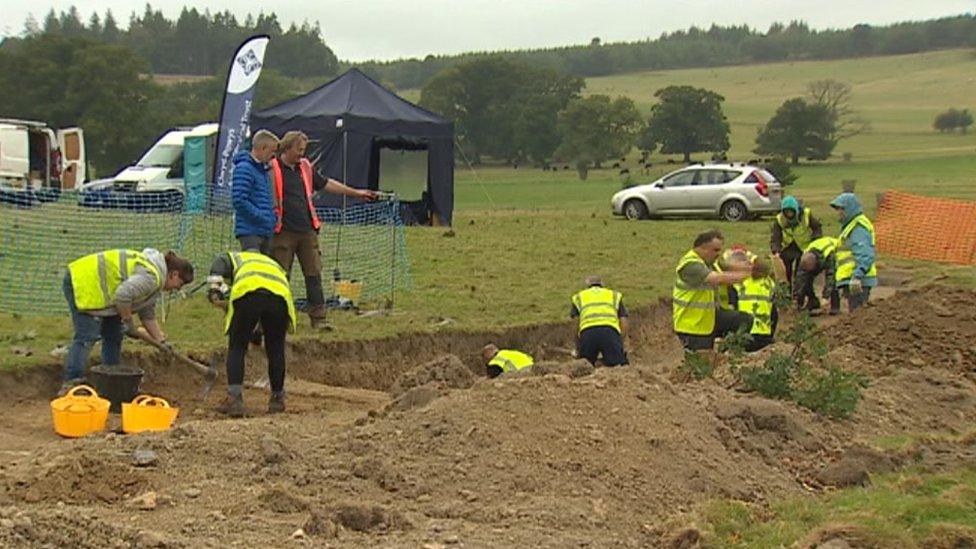 Dig site workers in high-viz jackets start excavations