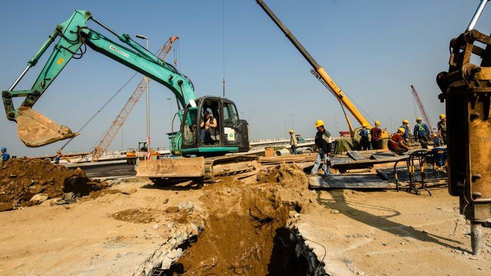 In this picture taken on December 6, 2017, labourers work on a road that leads to an artificial island which was built for the Hong Kong-Zhuhai-Macau Bridge