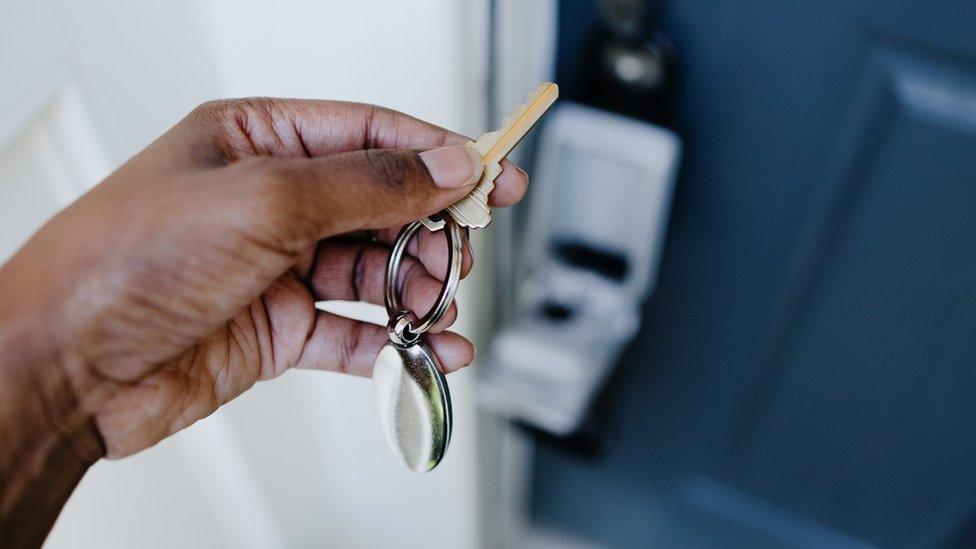 A hand holding a house key