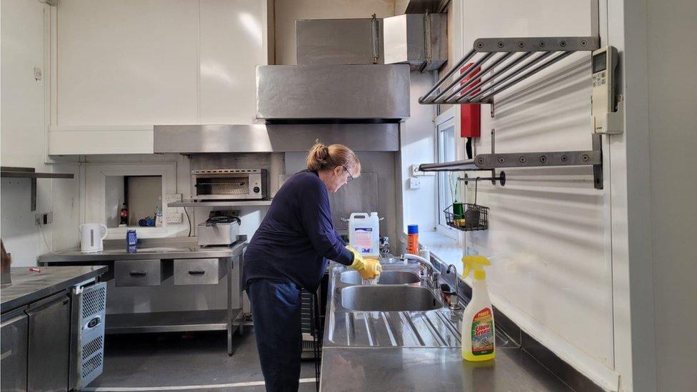 A person cleans a kitchen