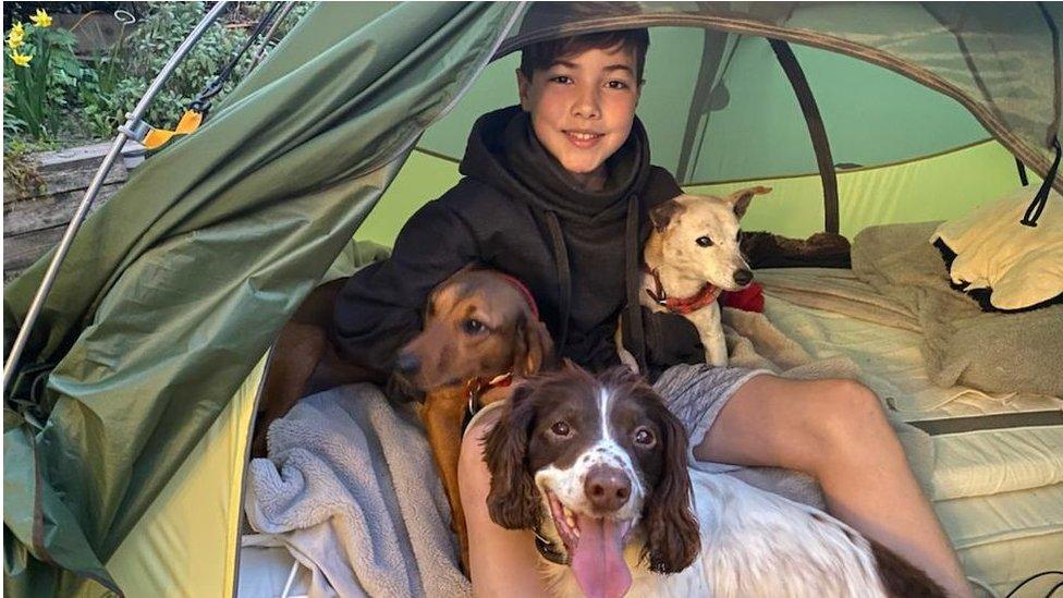 Ashley in his tent accompanied by his three dogs