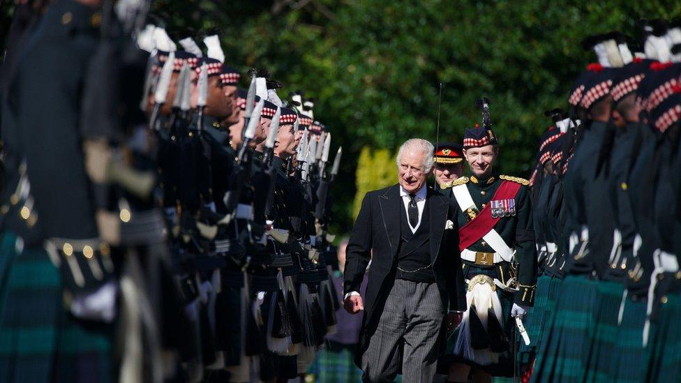 King Charles inspects an honour guard at the Palace of Holyroodhouse