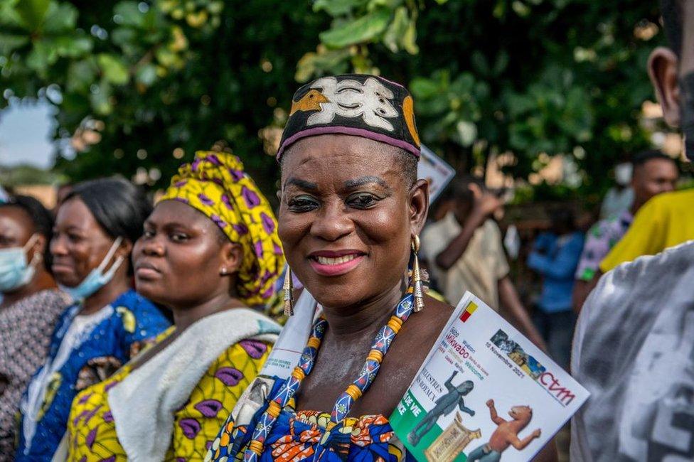 People smile, dance and cheer as a truck carrying artefacts, some considered sacred in Benin, arrive in Cotonou.