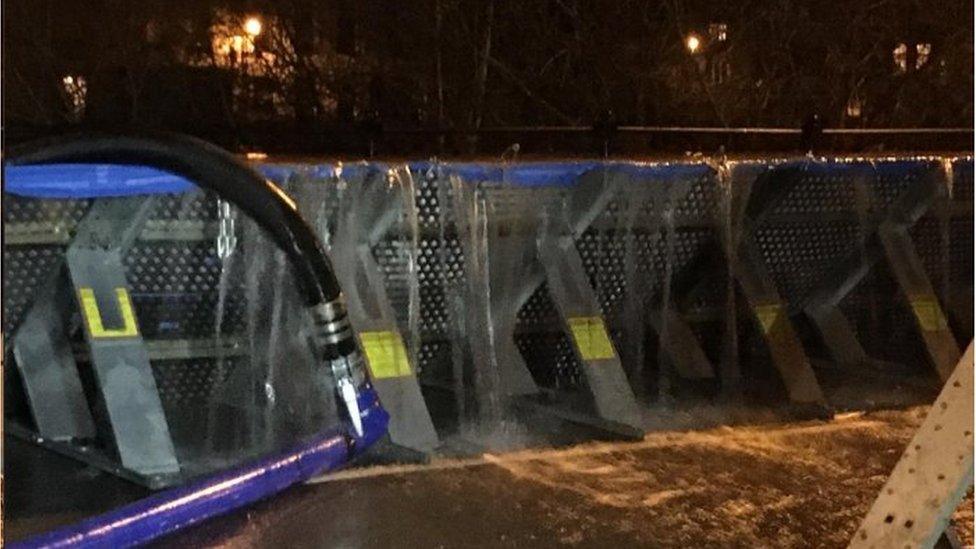 Water pouring over flood barriers in Bewdley, Worcestershire