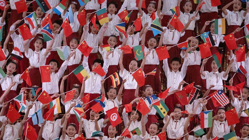 Chinese children holding their countries flag alongside African countries' flags to welcome African leaders to Beijing - Wednesday 4 September 2024