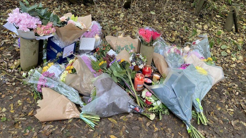 Flowers, candles and messages left on the ground  