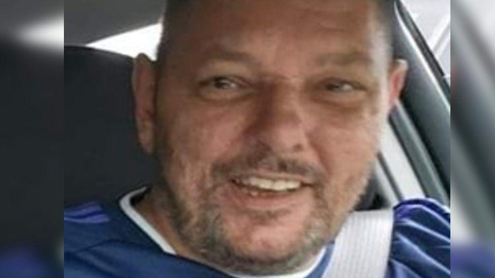 Nigel Barclay - smiling man wearing a dark blue shirt, The picture is taken inside a car.