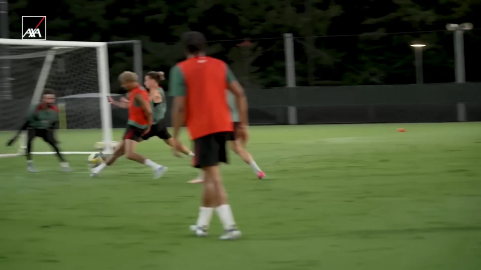 Screengrab from a behind-the-scenes training video showing Ekitike scoring with a toe-poke against Tsimikas and Alisson.