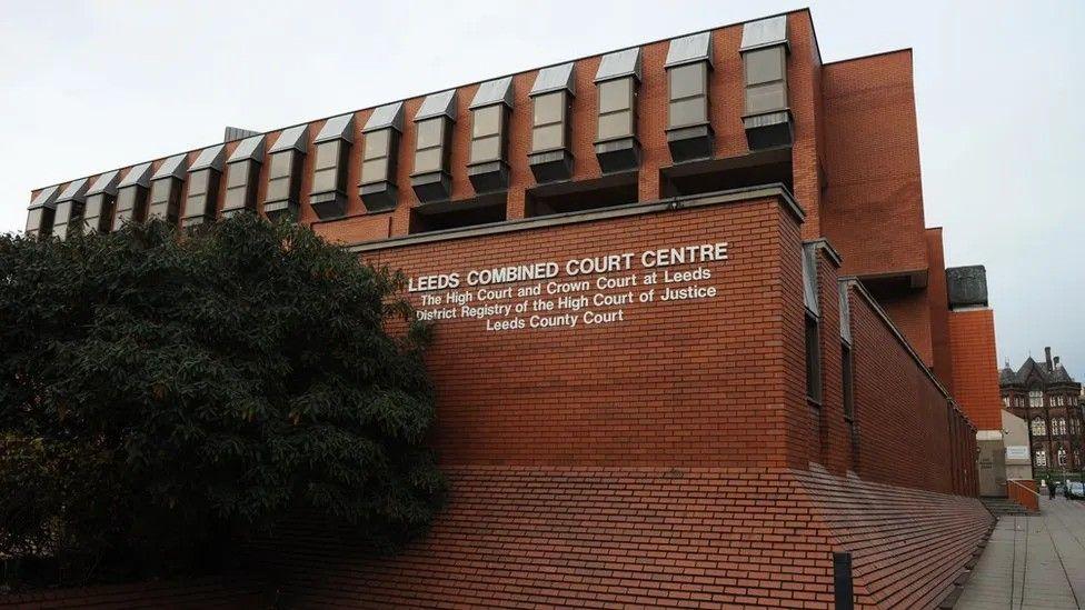 Leeds Crown Court, a redbrick building with a sign indicating its use.