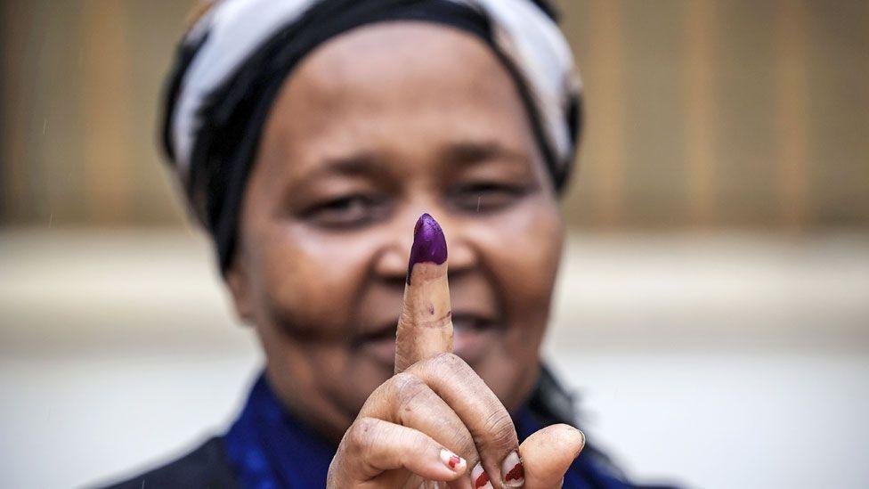 A voter in Mozambique showing her inked finger