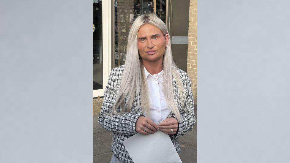 Samantha Morris outside Crook Civic Centre, County Durham. She has blonde hair and wears a chequered jacket and white shirt.