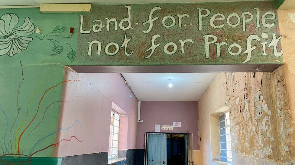 Mural saying 'land for people not for profit'