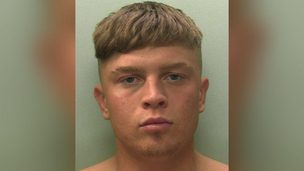 A police mugshot of Lawry Alison. He has blonde hair, a short beard and is without a shirt.