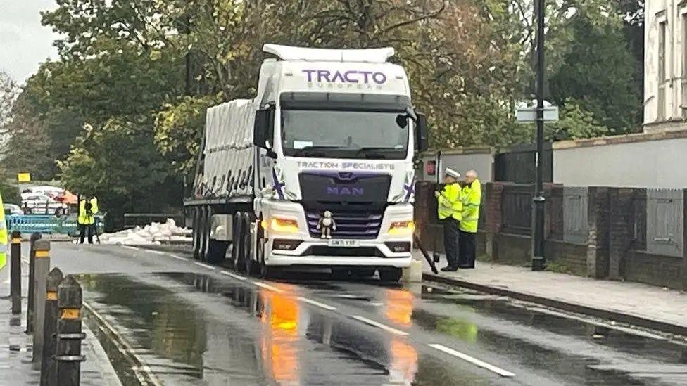 The lorry pulled over at the side of the road with police officers stood next to it in high vis