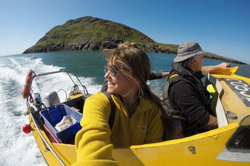 Mari Huws ar gwch gyda Enlli yn y cefndir