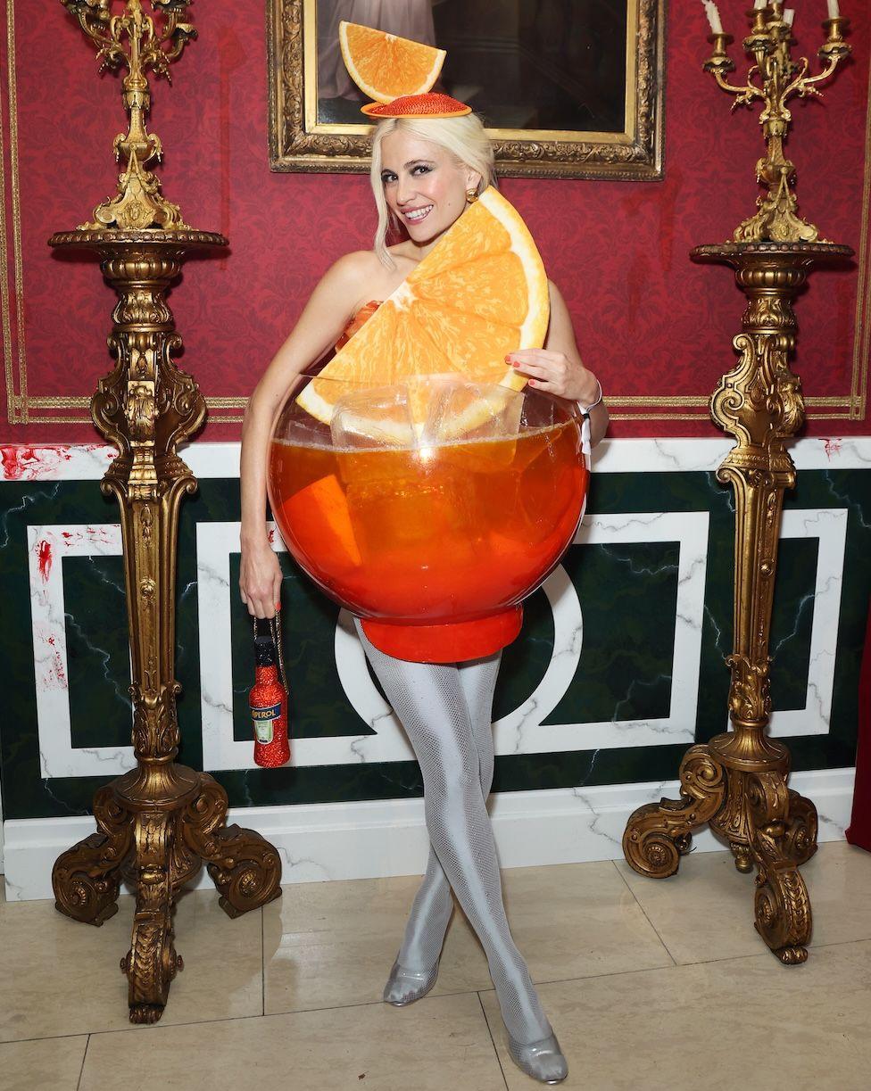 Pixie Lott wearing a cocktail glass of an Aperol Spritz.