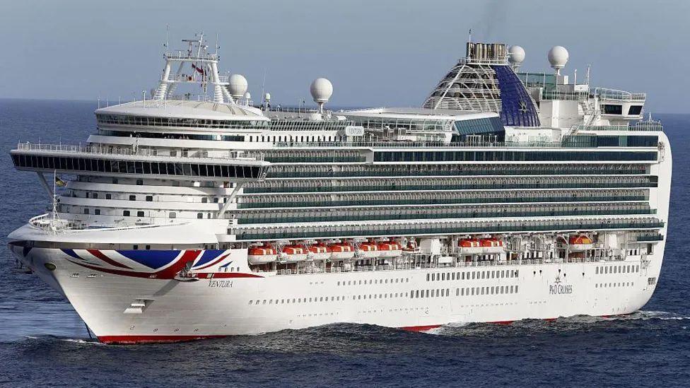 Large white cruise ship, Ventura at sea, with union flag logo on the bow