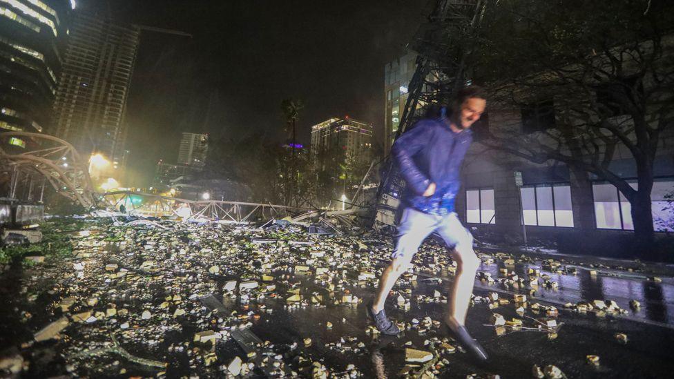 Man running in front of fallen crane