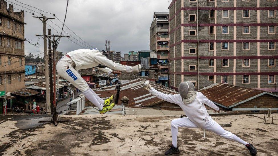 Two Kenyans wearing white fencing gear fight in the streets of Nairobi 9 June