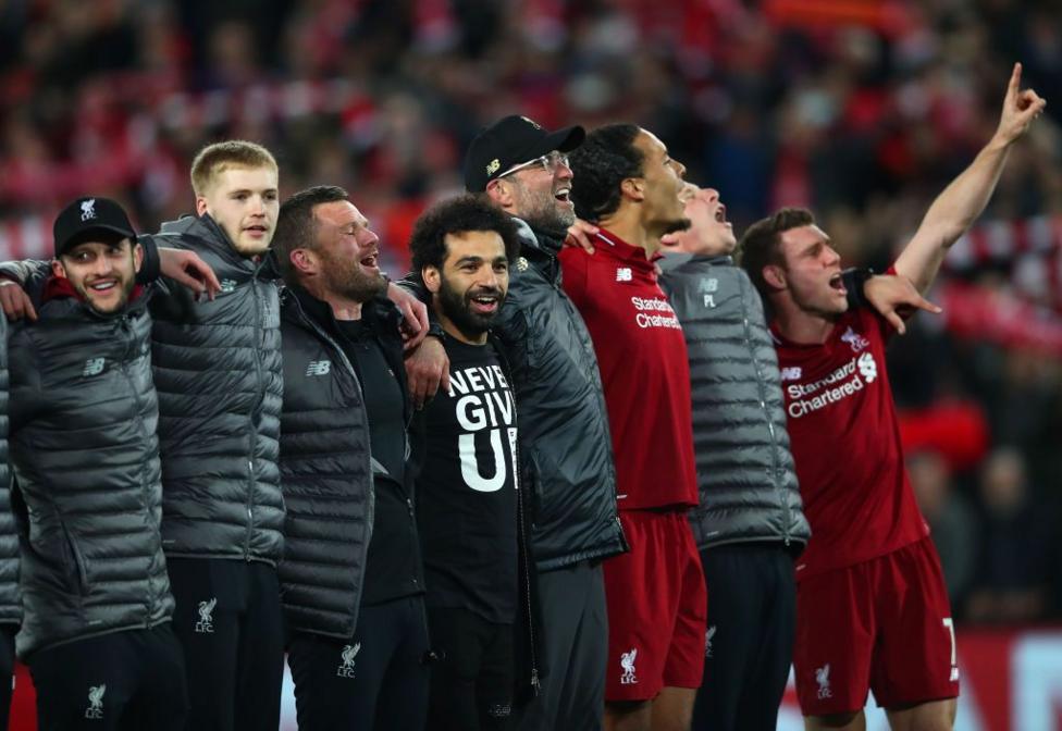 Mohamed Salah and Jurgen Klopp celebrate alongside other players and staff members in front of the Kop after Liverpool's 4-3 Champions League victory over Barcelona in May 2019