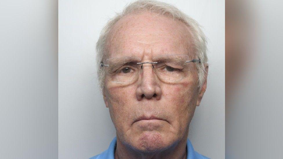 Police mugshot of Michael Haynes, who is wearing glasses and frowning at camera