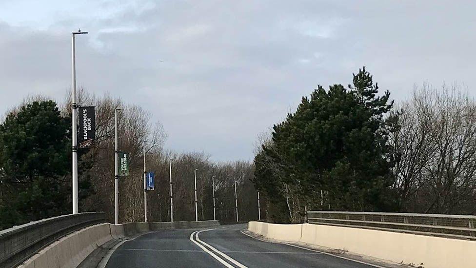 Street in Blackpool lined with LED street lights and trees.