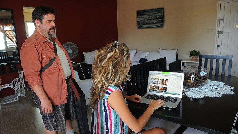 A Cuban woman provides a reservation service from a laptop in a rental house in Havana