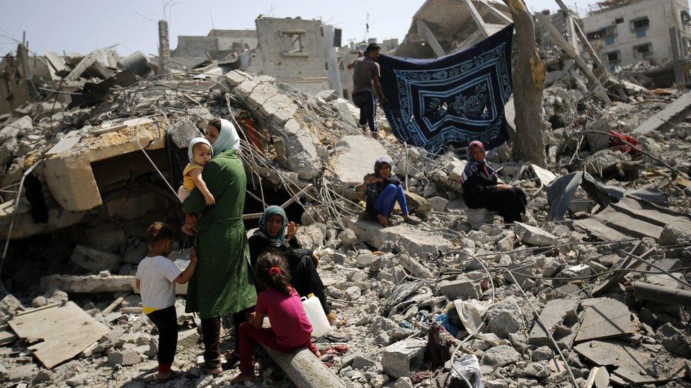 A family inspects the remains of their destroyed home in Beit Hanoun, in the northern Gaza Strip (1 August 2014)