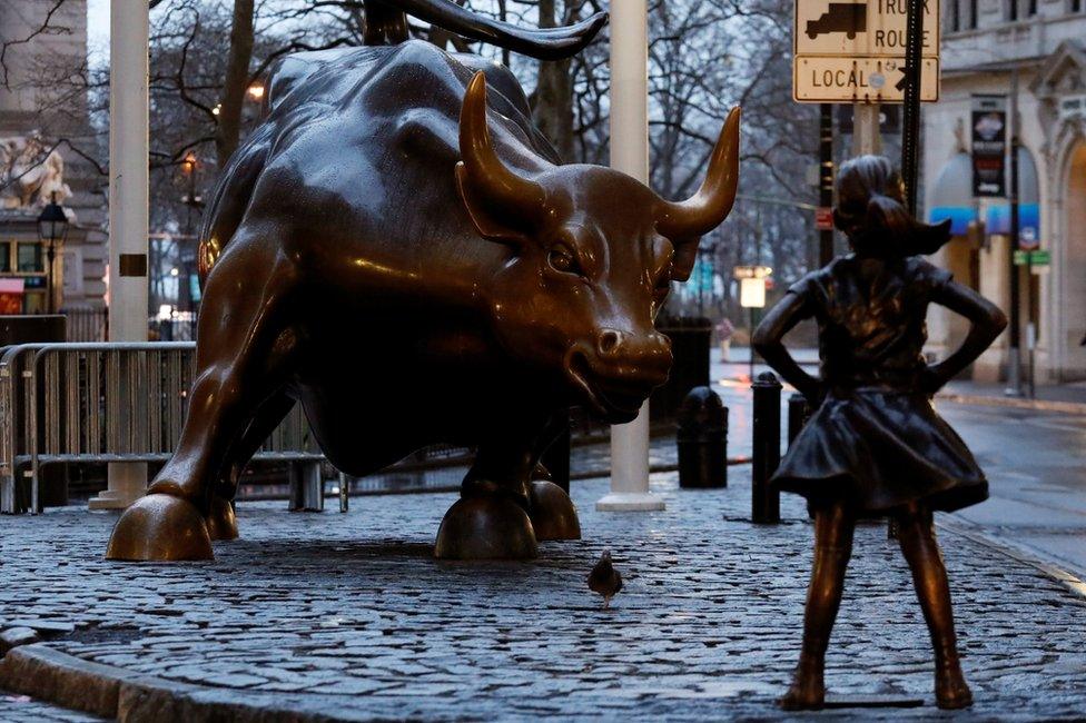 A statue of a girl facing the Wall St. Bull is seen, as part of a campaign by a US fund manager State Street to push companies to put women on their boards, in the financial district in New York