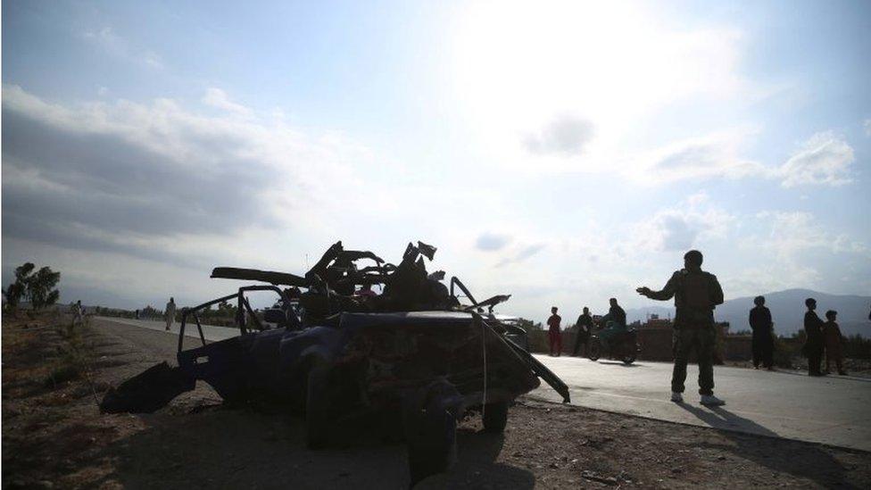 Afghan security officials inspect the scene of a road side bomb blast that killed six civilians on the outskirts of Jalalabad, Afghanistan, 21 July 2021.