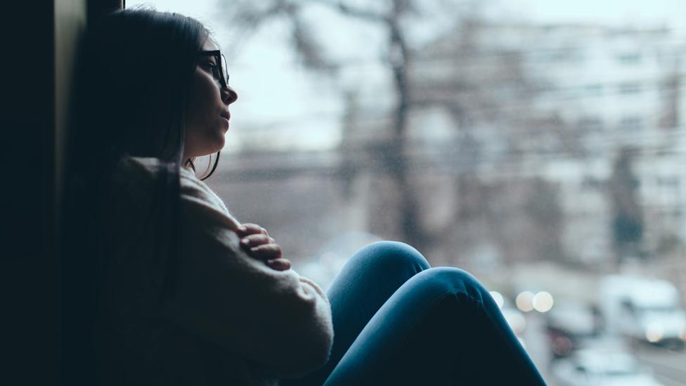 Teenager looking out of a window