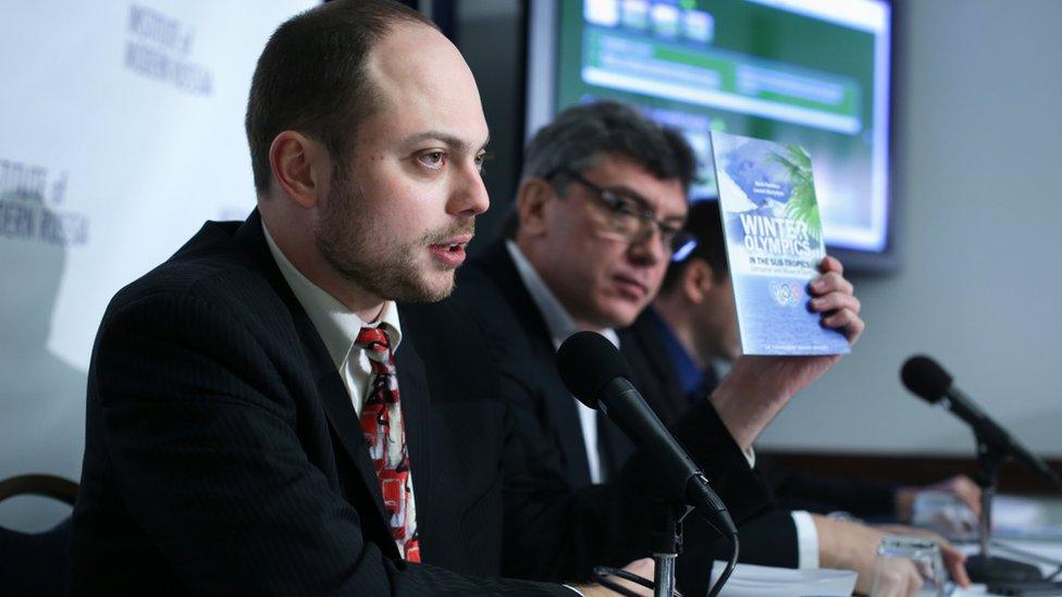 Vladimir Kara-Murza holds up a copy of the report on "Winter Olympics in the Sub-Tropics" as Russian opposition leader and former Deputy Prime Minister Boris Nemtsov listens in January 2014