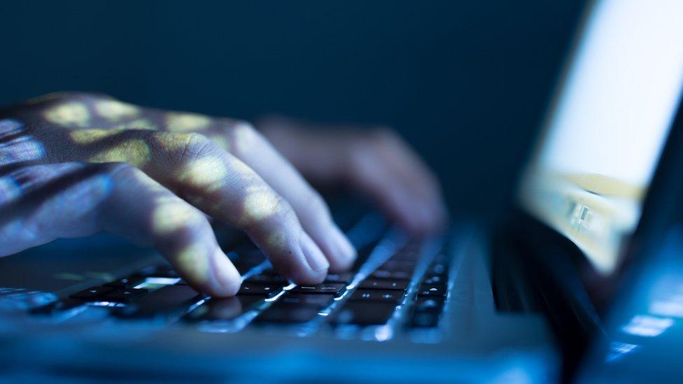 Fingers on a laptop keyboard